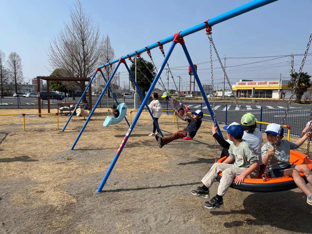 3連ブランコという遊具で遊ぶこどもたちの画像