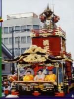 加藤清正像が上に立っており中央に黄色い着物を着た3人の人が座っている本庄七軒町の山車の写真