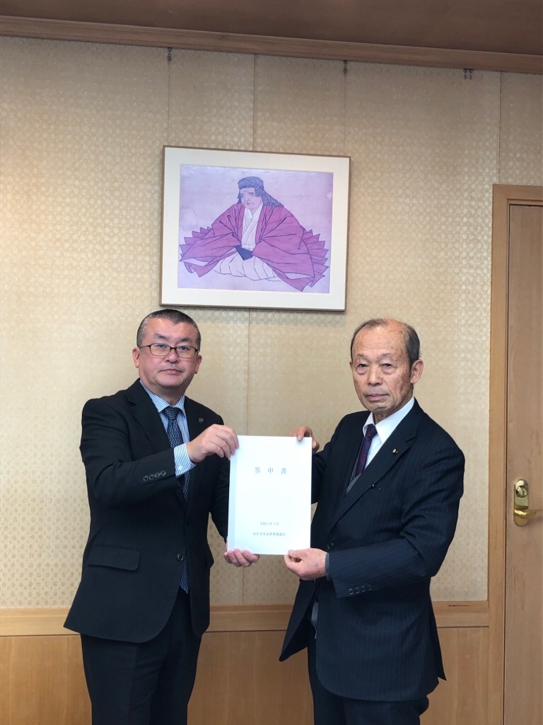 令和6年3月28日に吉田信解市長(左)へ 答申書を渡す小林猛水道事業審議会会長(右)