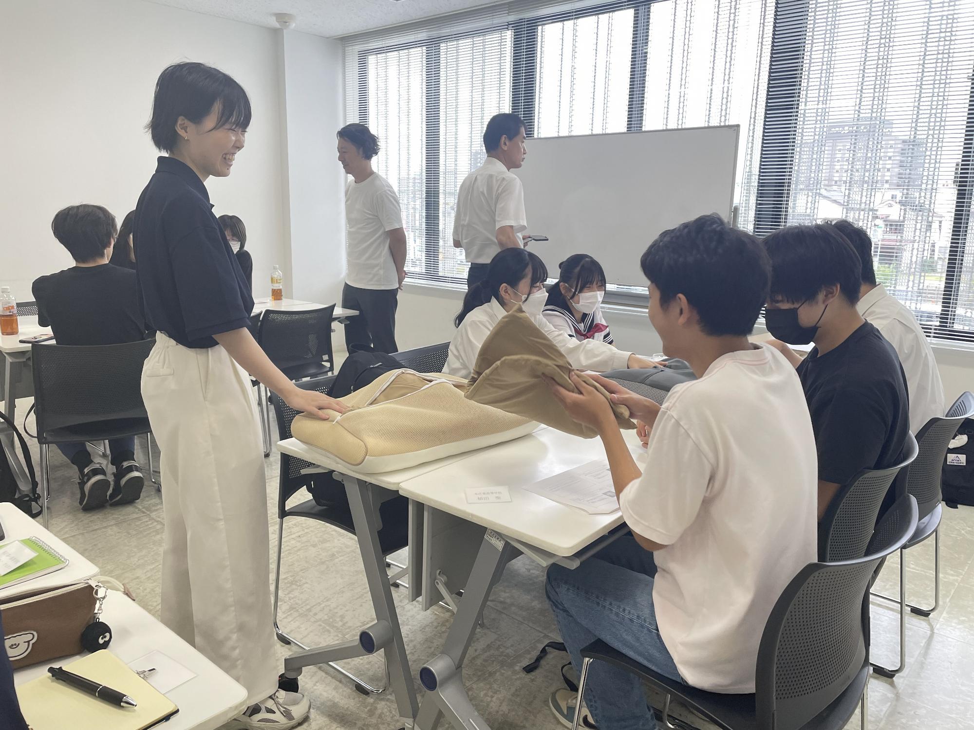 まくらの触り心地を試す高校生