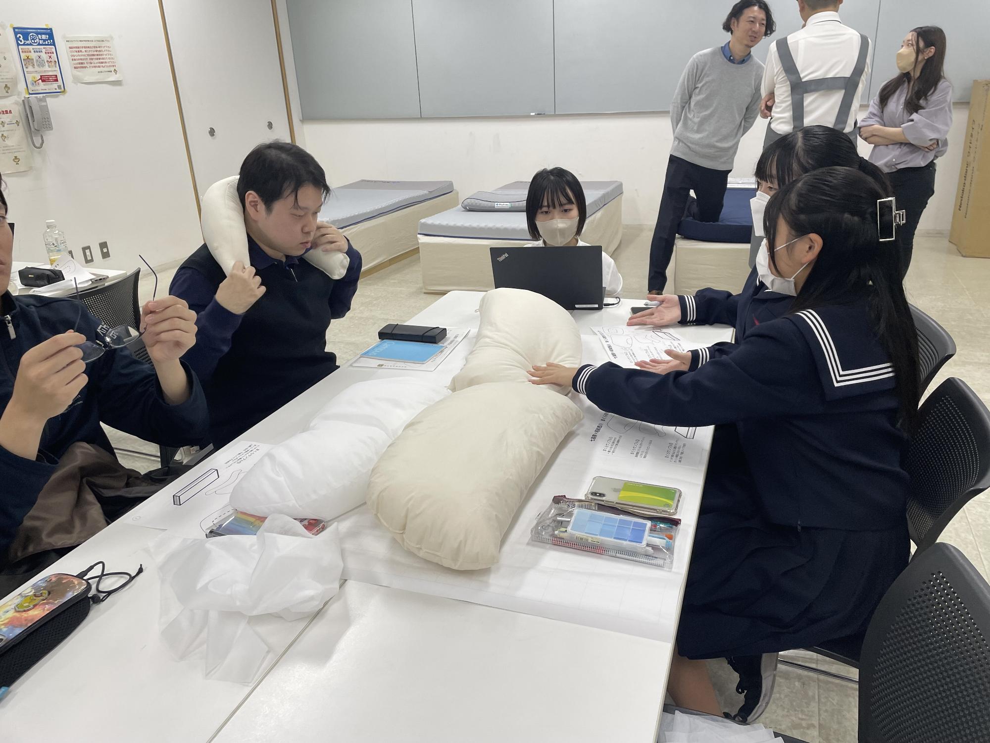 まくらのサンプルを確認する学生