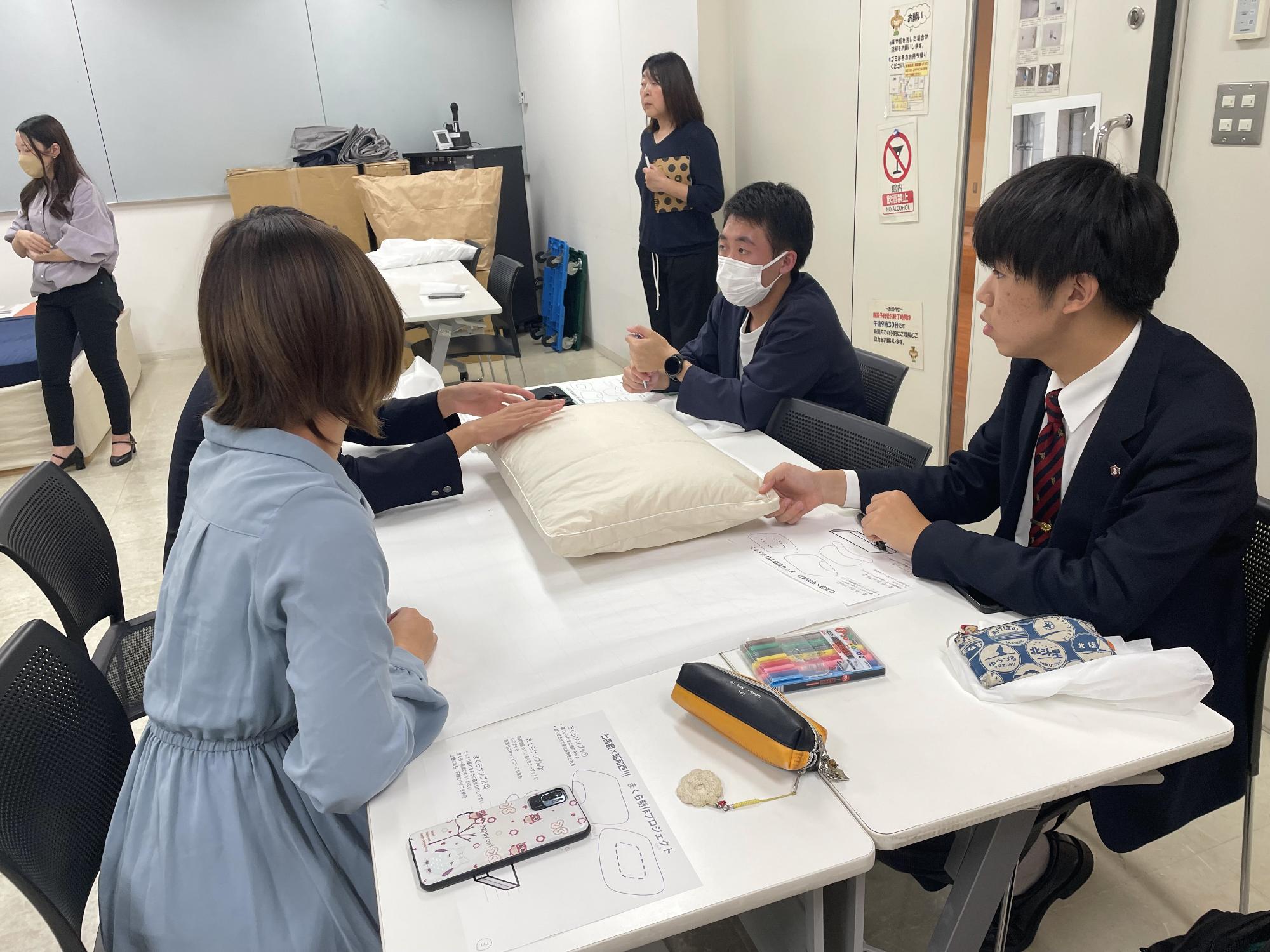 まくらのサンプルを確認する学生