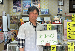 おまつりさいこうと書かれたスケッチブックを持った男性