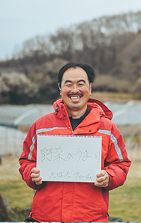 野菜がうまい！たばたファームと書かれたスケッチブックを持った男性