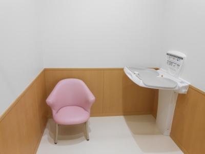 ピンクの椅子とおむつ交換台の写真