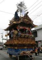 人形座は一段で中央に4つの太鼓と人々が乗っている児玉本町の山車の写真