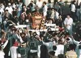 祇園まつりでグレーの法被を着た人たちが神輿を担いでいる写真