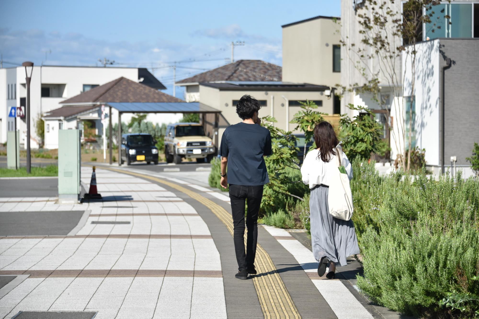 早稲田の杜の歩道を歩く夫婦の写真