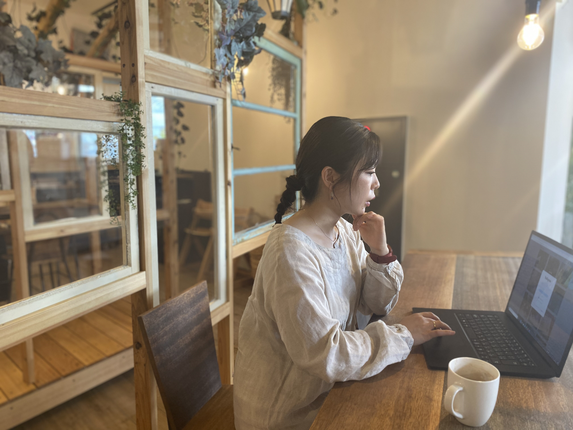 カフェでパソコン作業をする女性の写真
