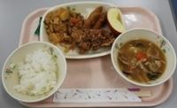 給食のお盆の左下にご飯、右下にスープ、中央におかずが置かれてある給食の写真