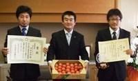 トマトが入った箱を持っている市長と賞状を手に持った本庄の農業の方2名の写真