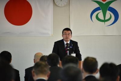 日の丸国旗と市章の前に立って演壇で市長就任訓示を述べている吉田市長の写真