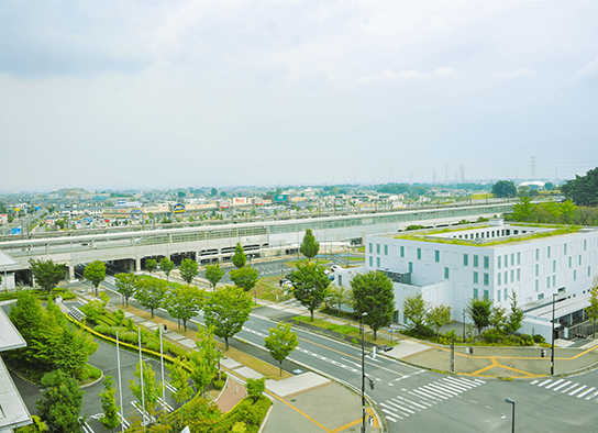 斜め上から見た本庄早稲田駅周辺の街並み。道路や建物、空が写っている。